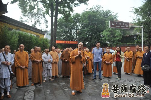 文殊院监院能干法师向与会来宾介绍山门外的免费赠香提示牌