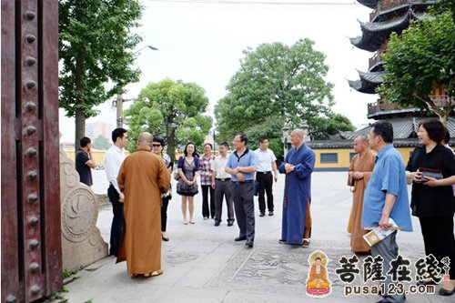 龙华古寺方丈照诚大和尚等在山门口迎接程副局长,王副区长